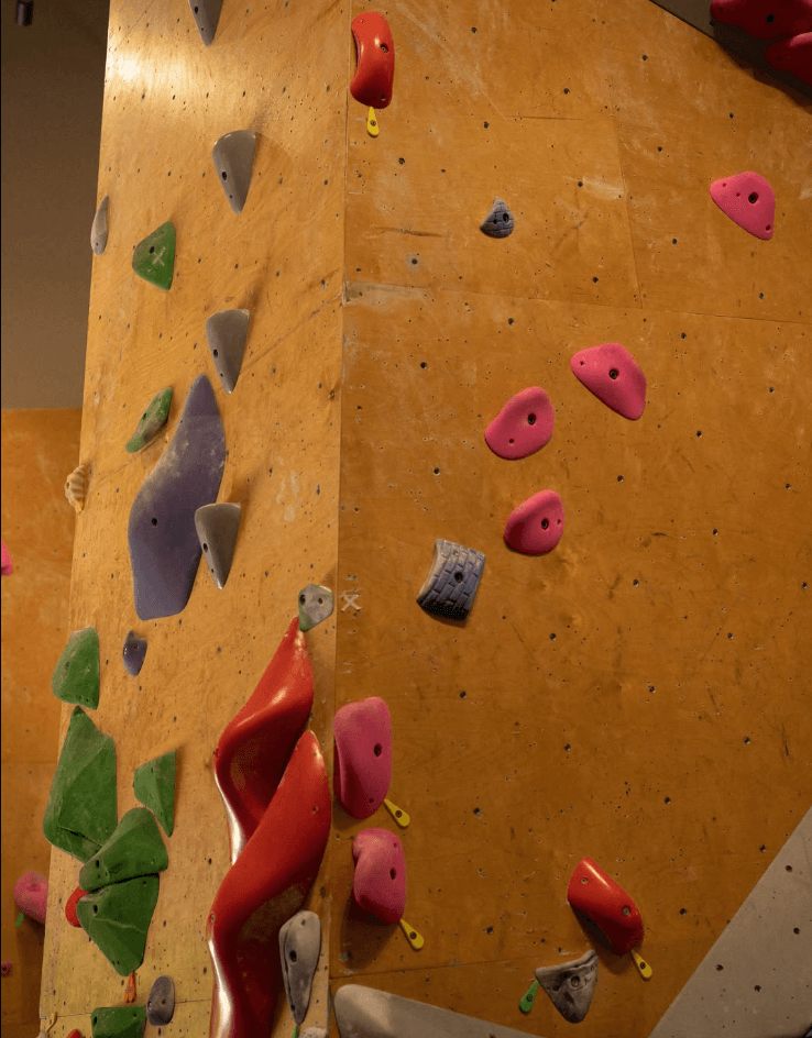 Climbing gym wall with routes marked by colorful tags
