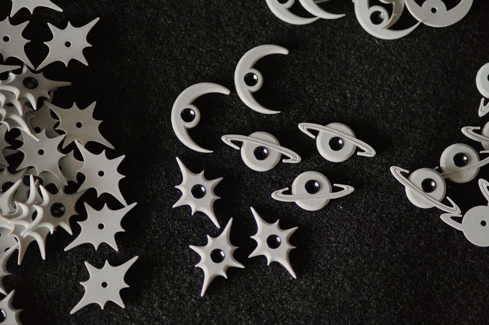 Overhead shot of star, crescent, and ringed-planet route tags arranged on black felt