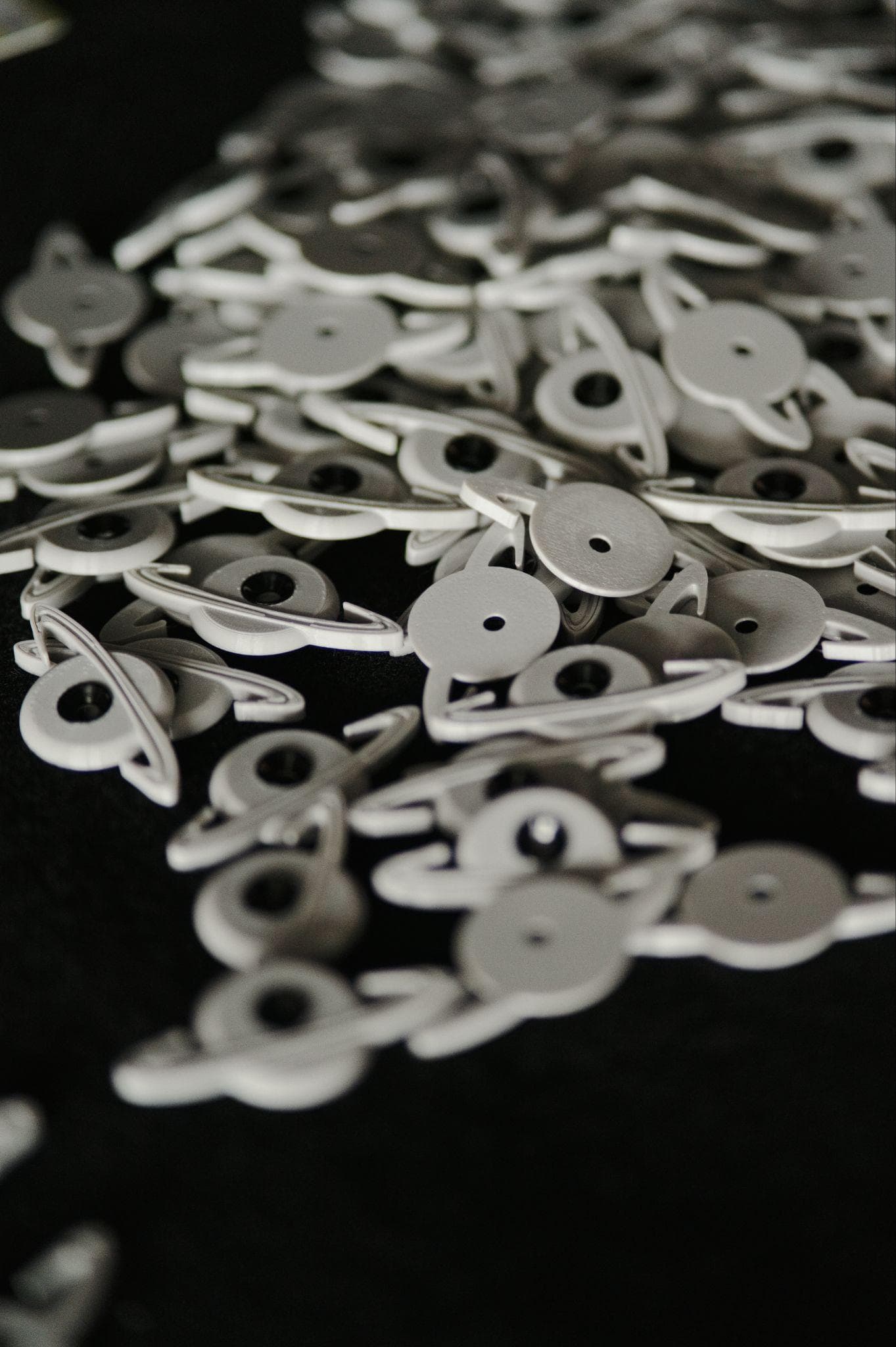 A pile of white ringed-planet route tags scattered across black felt